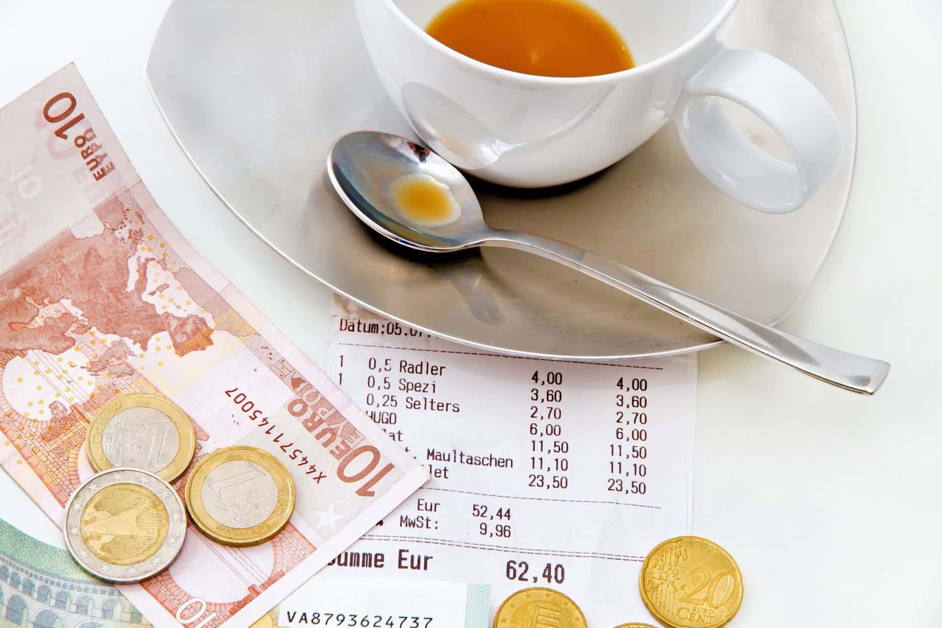 Kaffeegeschirr und Geld liege auf einem Tisch